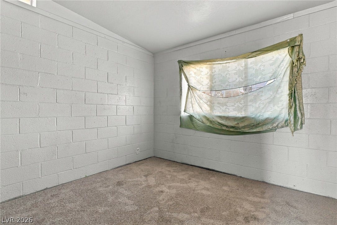 2521 Perliter Avenue, North Las Vegas, NV 89030 Industrial style concrete block walls and wall-to-wall carpeting define this versatile interior space.