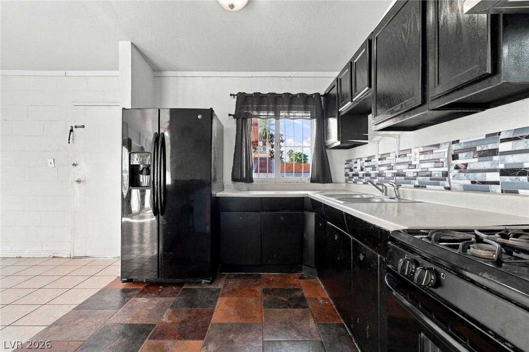 2521 Perliter Avenue, North Las Vegas, NV 89030 Dark cabinetry anchors this functional kitchen space complete with durable tile flooring.