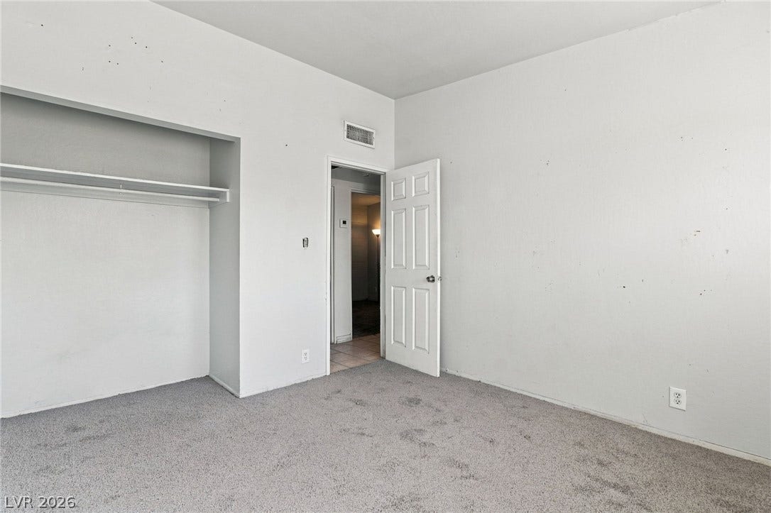2521 Perliter Avenue, North Las Vegas, NV 89030 A classic six-panel door opens into a bedroom with plush carpeting and built-in closet shelving.