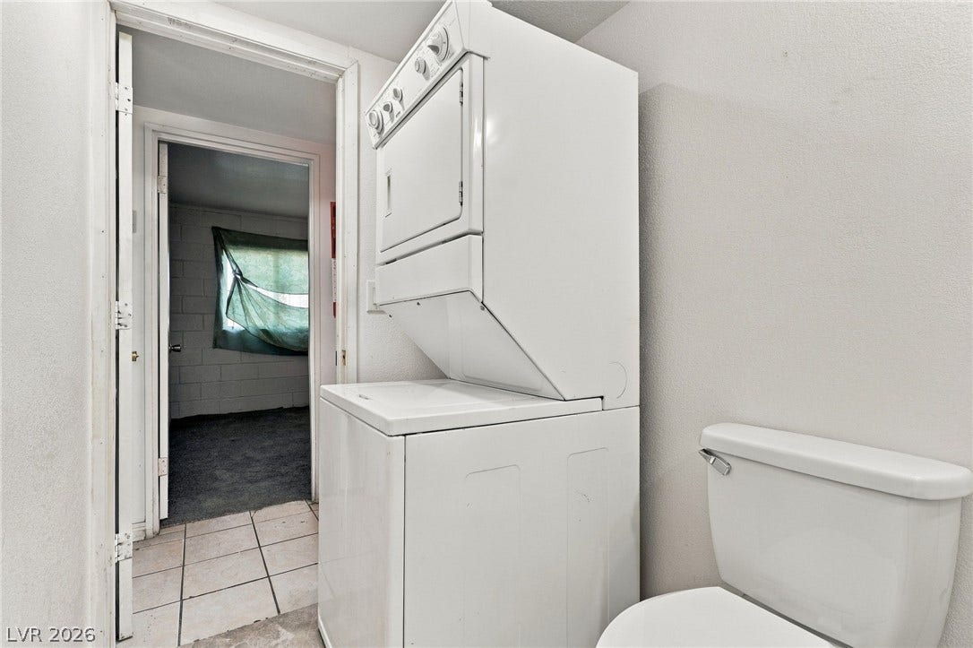 2521 Perliter Avenue, North Las Vegas, NV 89030 A compact laundry setup maximizes utility near a tiled transition and adjacent room.
