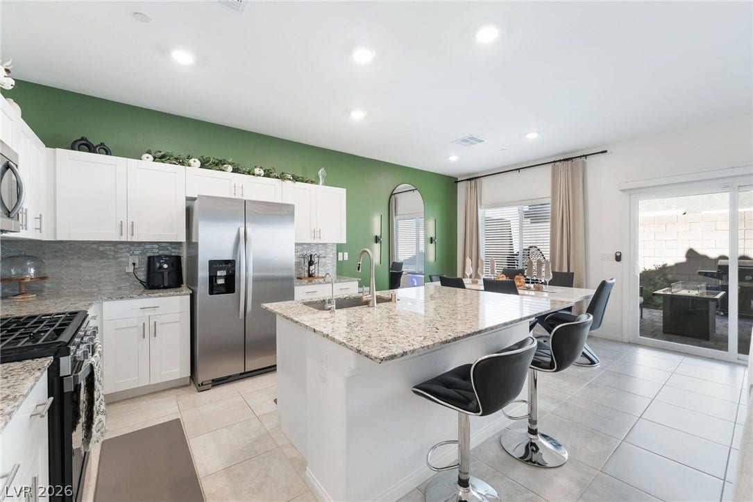 10958 Cheshire Woods Avenue, Las Vegas, NV 89166 Polished stone countertops and clean tile flooring define this modern culinary workspace.