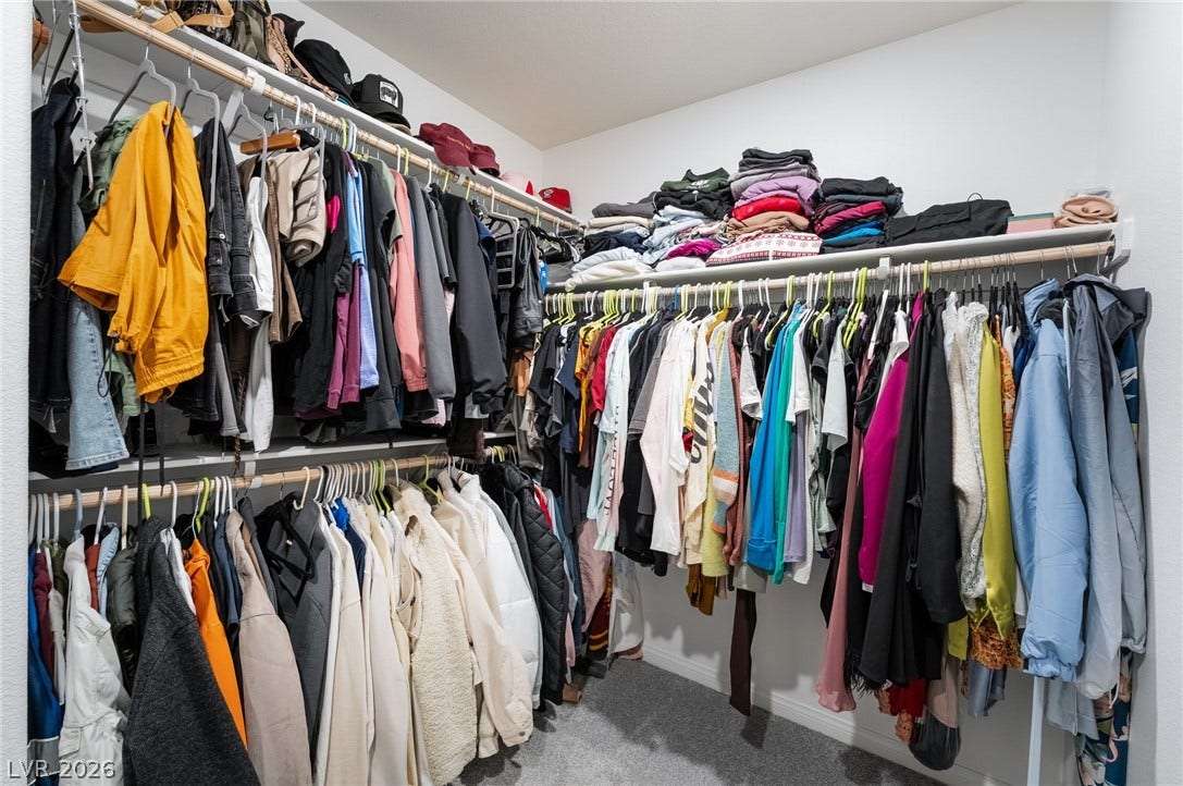 10958 Cheshire Woods Avenue, Las Vegas, NV 89166 Ample hanging space and shelving define this walk-in closet with plush carpeting.