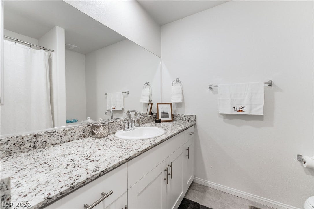 10958 Cheshire Woods Avenue, Las Vegas, NV 89166 Polished granite countertops bring enduring style and natural texture to this modern bathroom vanity.