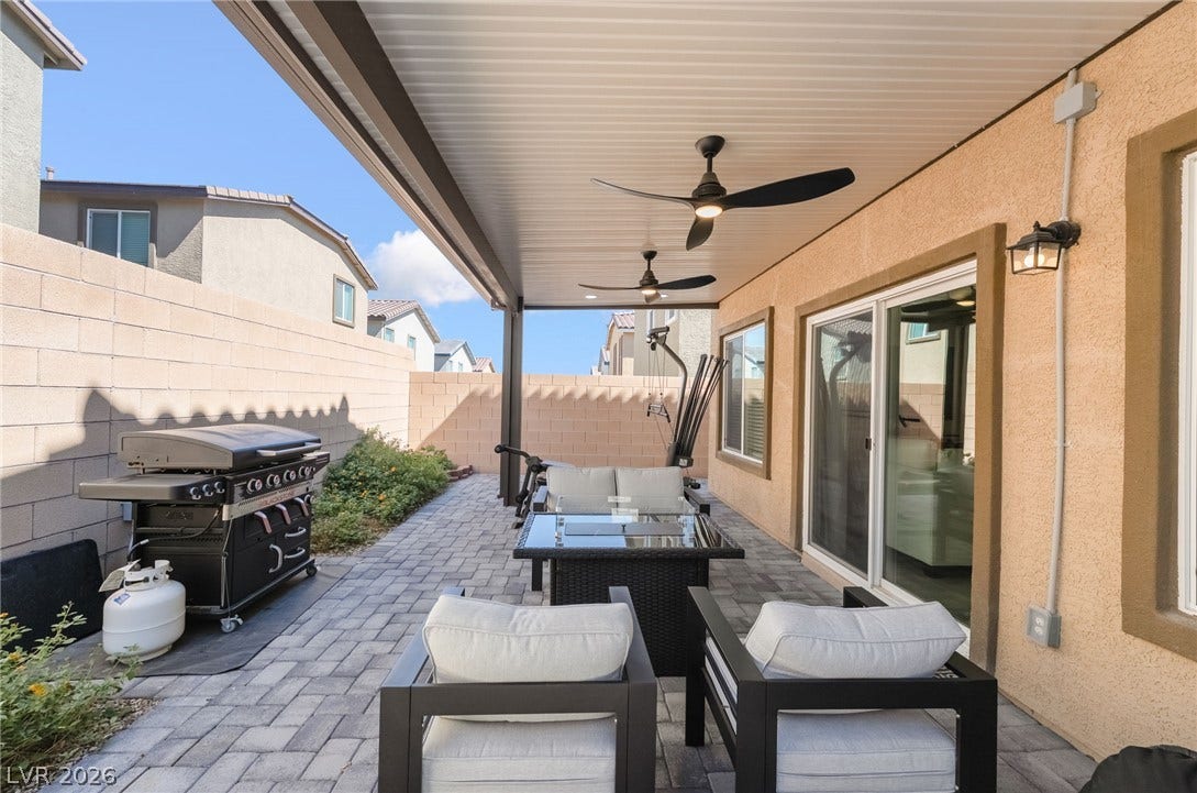 10958 Cheshire Woods Avenue, Las Vegas, NV 89166 A covered patio with paved flooring sits adjacent to a private backyard space.