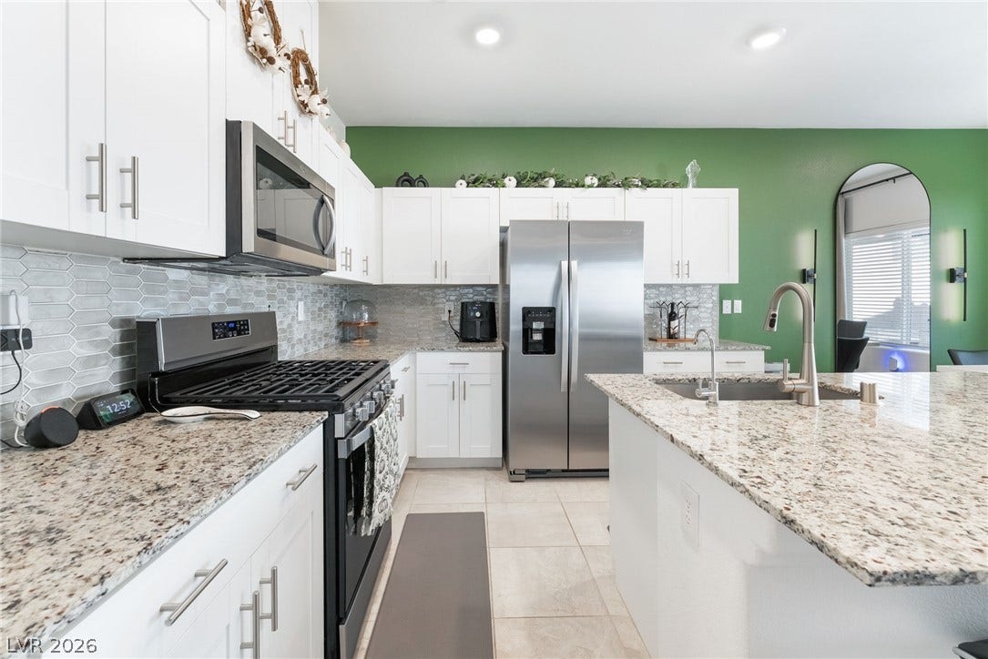 10958 Cheshire Woods Avenue, Las Vegas, NV 89166 Polished granite countertops and classic shaker cabinetry anchor this airy culinary space.