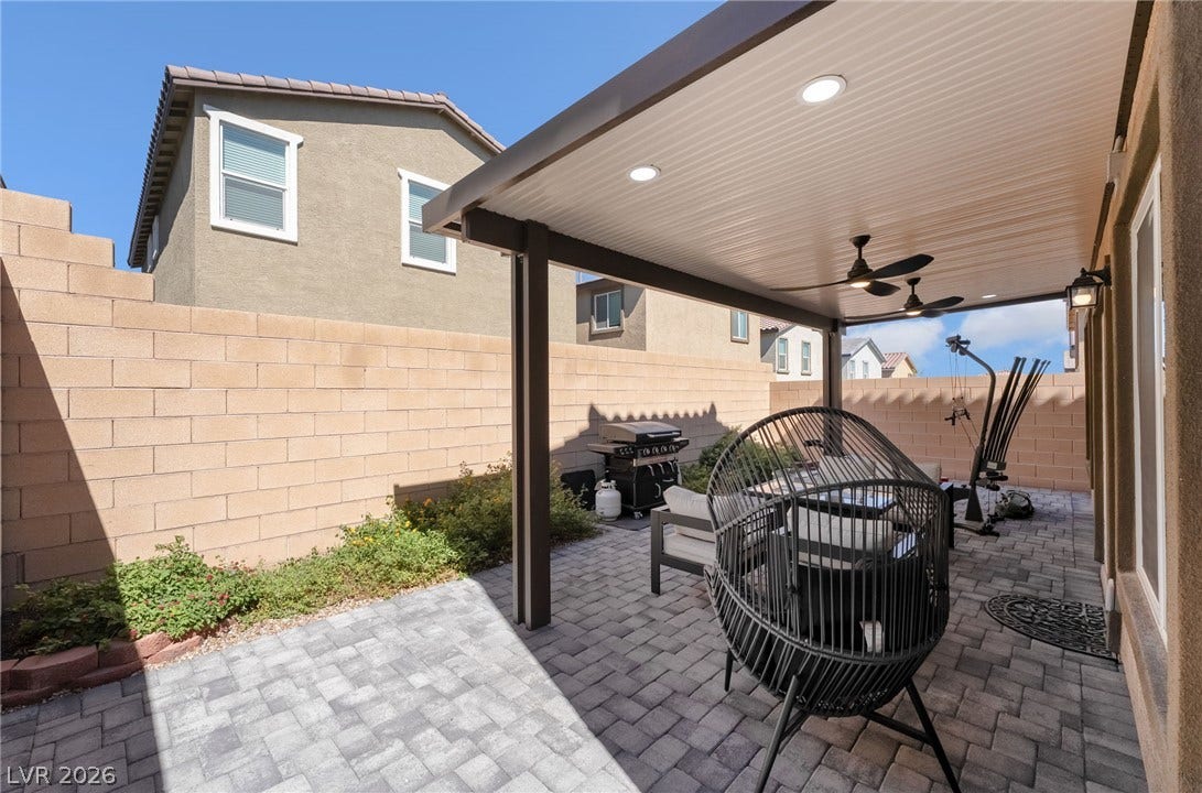 10958 Cheshire Woods Avenue, Las Vegas, NV 89166 A spacious covered patio features elegant paver stone flooring alongside a walled perimeter.