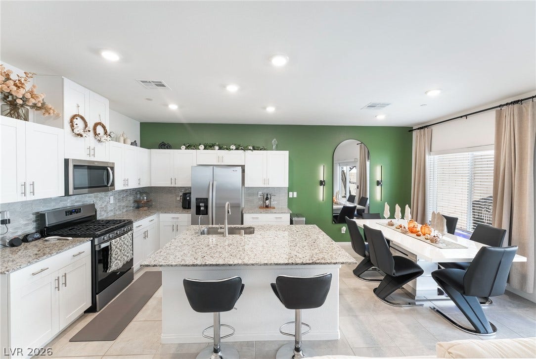 10958 Cheshire Woods Avenue, Las Vegas, NV 89166 Polished granite countertops and clean tile flooring define this modern open-concept culinary space.