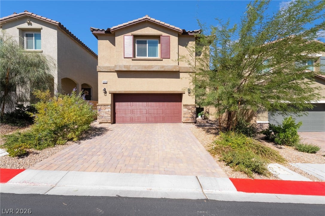 10958 Cheshire Woods Avenue, Las Vegas, NV 89166 An inviting two-story stucco exterior stands behind a beautifully paved brick driveway.