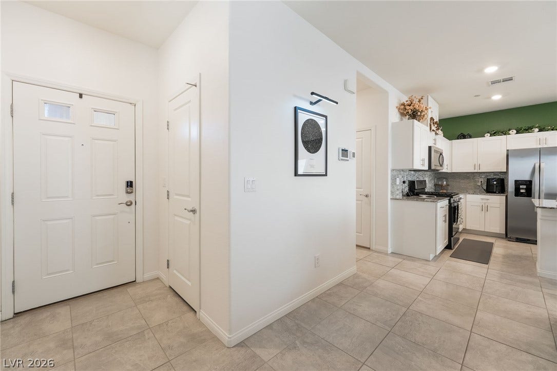 10958 Cheshire Woods Avenue, Las Vegas, NV 89166 Tiled flooring flows seamlessly from the welcoming entry hall directly into the modern kitchen.