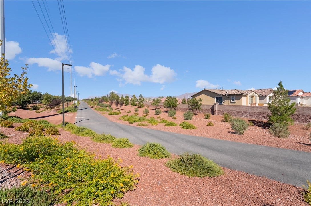 10958 Cheshire Woods Avenue, Las Vegas, NV 89166 A paved path meanders through desert landscaping beneath a clear blue sky.