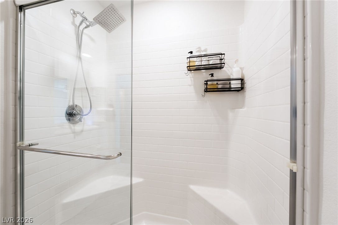 10958 Cheshire Woods Avenue, Las Vegas, NV 89166 Clean subway tile lines this walk-in shower complete with built-in bench seating.
