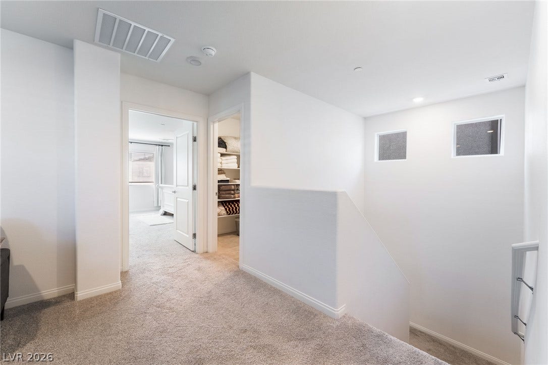 10958 Cheshire Woods Avenue, Las Vegas, NV 89166 An upper-level hallway featuring plush carpeting and a half-wall overlooking the staircase.