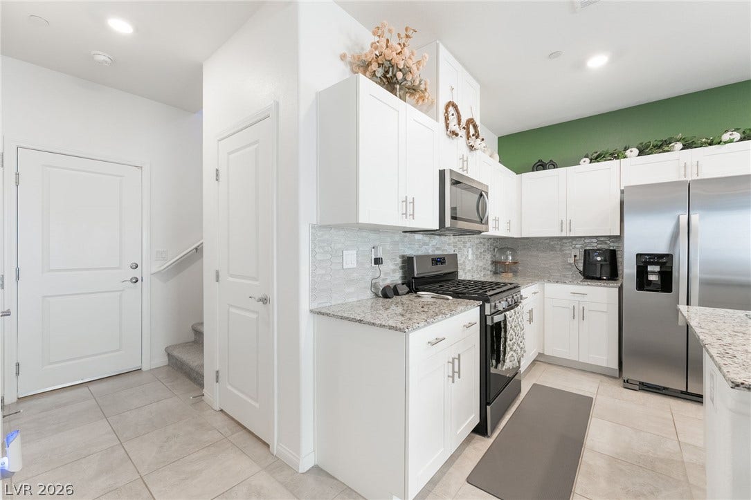 10958 Cheshire Woods Avenue, Las Vegas, NV 89166 Gleaming stone countertops and sleek cabinetry define this contemporary culinary space.