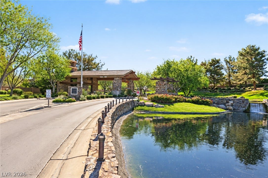 6 Mohansic Road, Henderson, NV 89052 A stone-paved entry road leads past a tranquil pond to the gated neighborhood entrance.