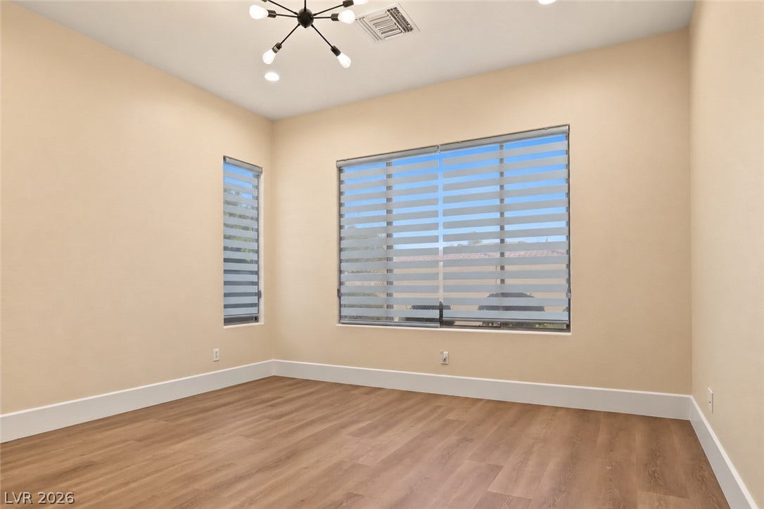 6 Mohansic Road, Henderson, NV 89052 Smooth wood-look flooring and tall windows create a warm, inviting atmosphere in this versatile room.
