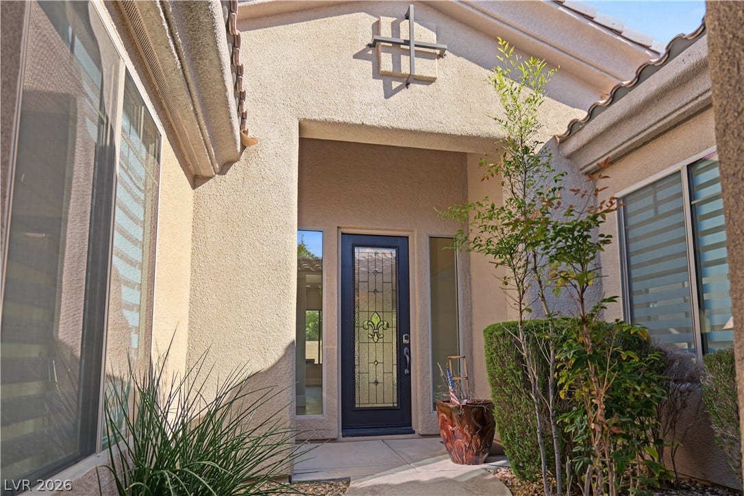 6 Mohansic Road, Henderson, NV 89052 A stucco entry alcove frames the decorative glass front door leading into the home.