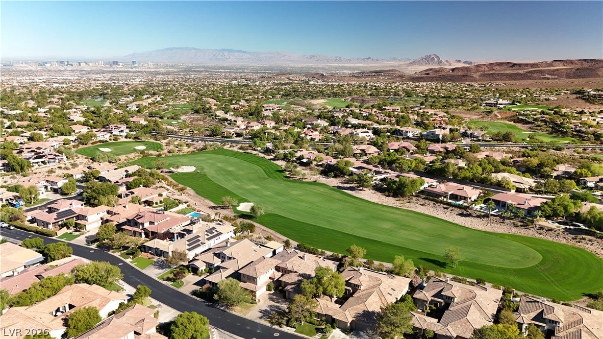 6 Mohansic Road, Henderson, NV 89052 An aerial perspective showcases a lush golf course winding through a desert neighborhood.