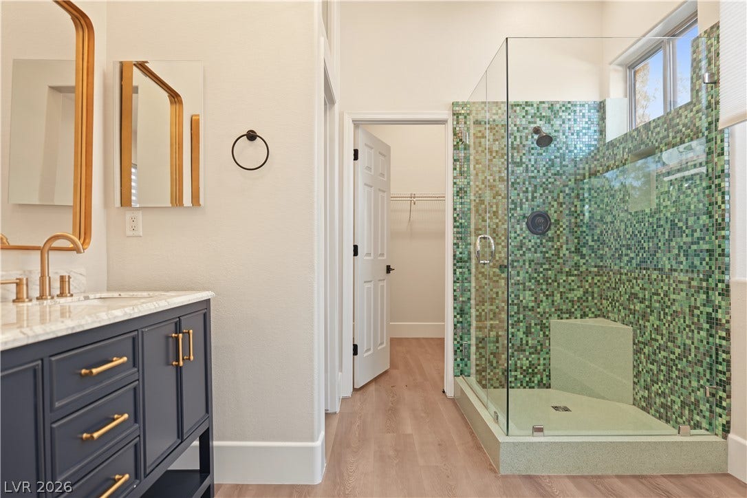 6 Mohansic Road, Henderson, NV 89052 A glass-enclosed walk-in shower features vibrant mosaic tile work alongside a modern vanity.