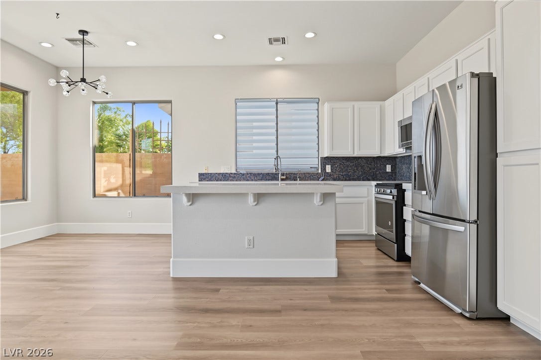 6 Mohansic Road, Henderson, NV 89052 Clean lines and recessed lighting define this open-plan culinary space with wood flooring.