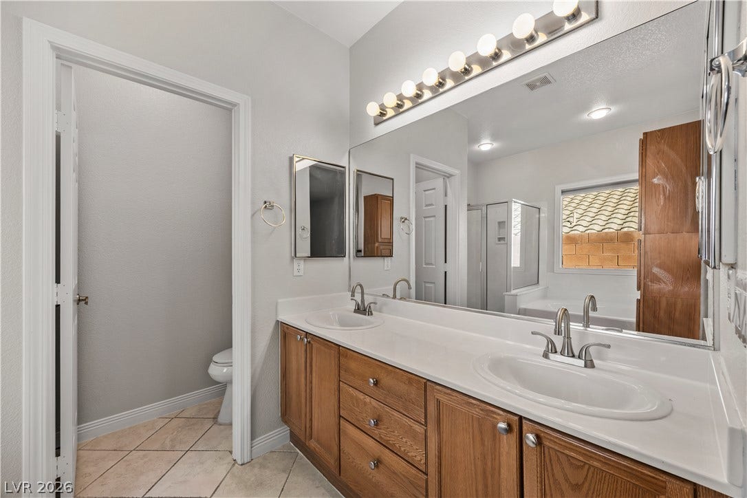 753 Wigan Pier Drive, Henderson, NV 89002 Double sinks accent the long vanity in this bright bathroom with ceramic tile flooring.