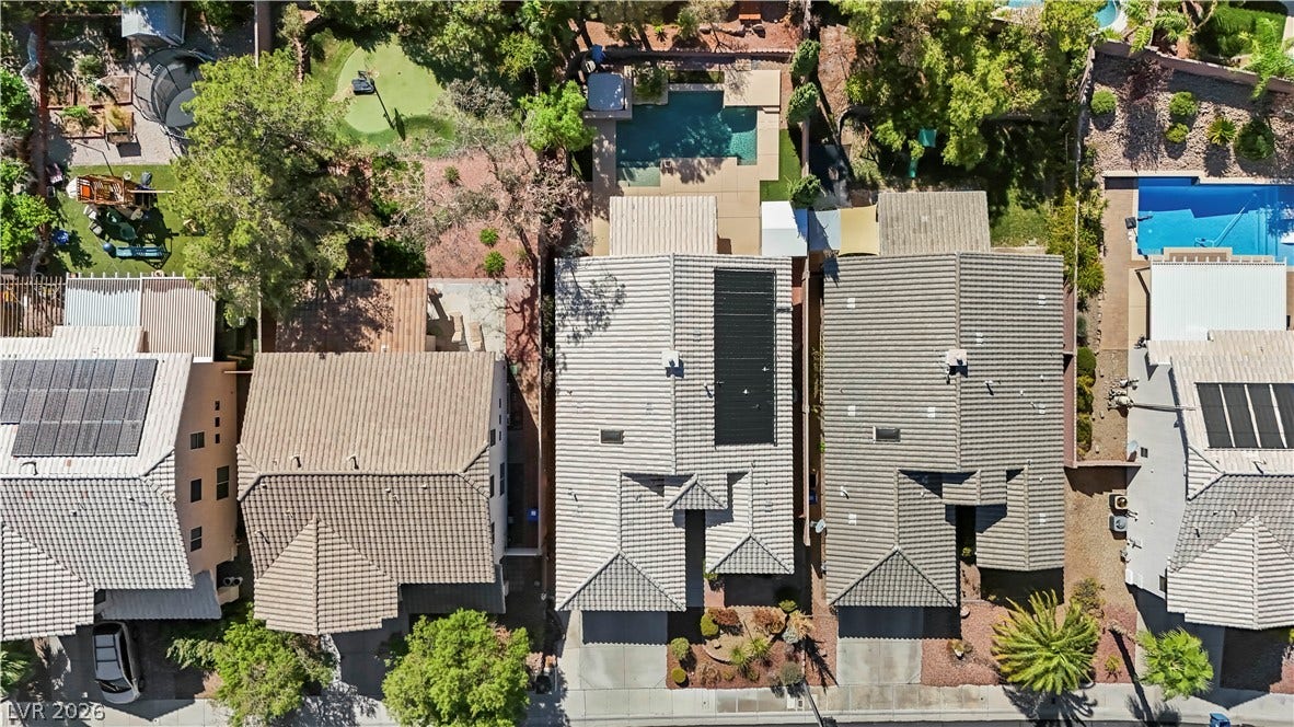 753 Wigan Pier Drive, Henderson, NV 89002 An aerial perspective showcases the tiled rooftops, solar panels, and backyard swimming pool of this property.