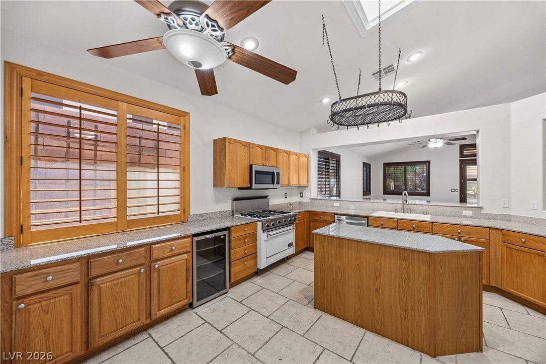 753 Wigan Pier Drive, Henderson, NV 89002 Gleaming stone countertops and warm wood cabinetry define this inviting culinary space.