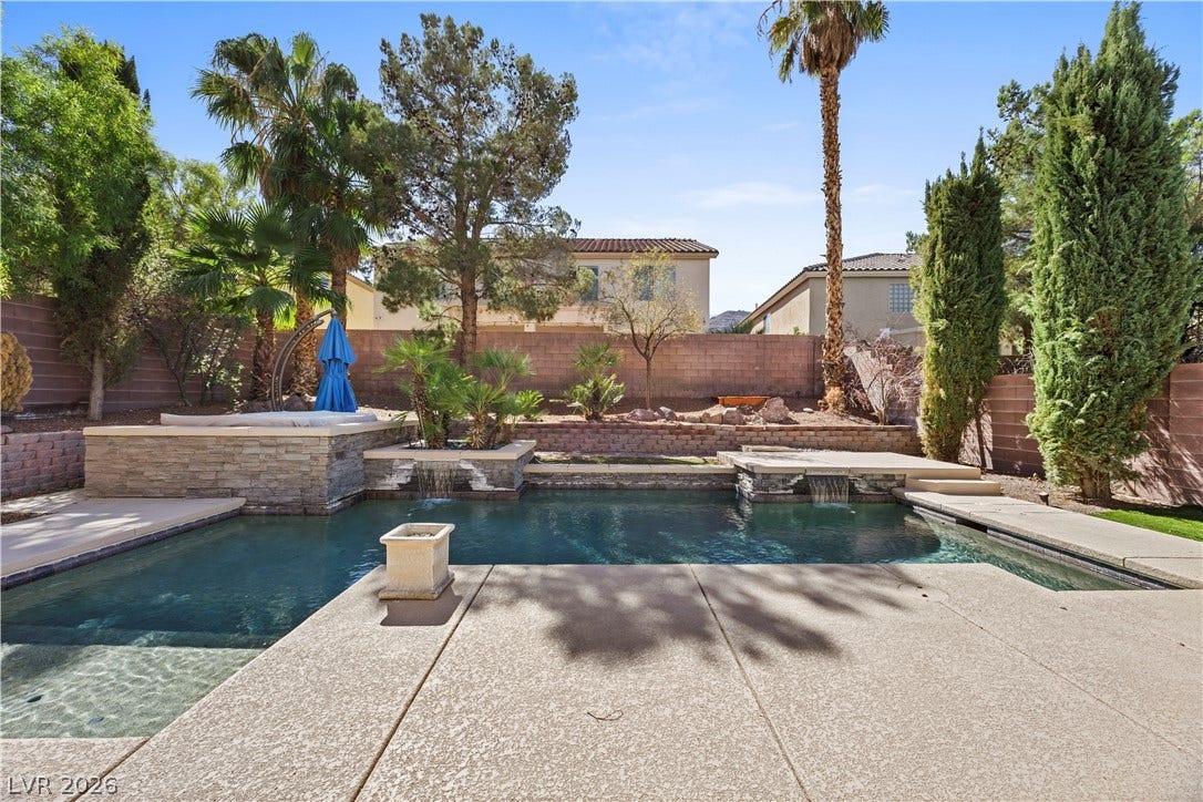 753 Wigan Pier Drive, Henderson, NV 89002 A sparkling swimming pool anchors the backyard retreat surrounded by mature landscaping and stone walls.