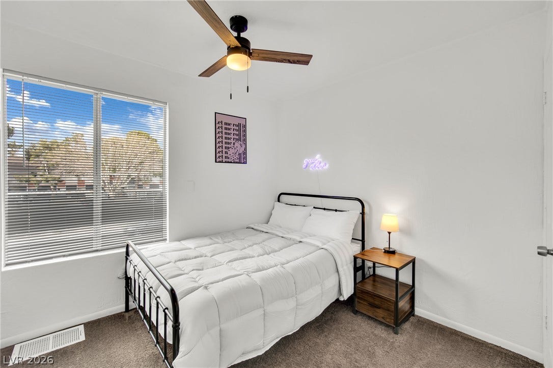 Plush carpeting and a large window create a comfortable, inviting atmosphere.
