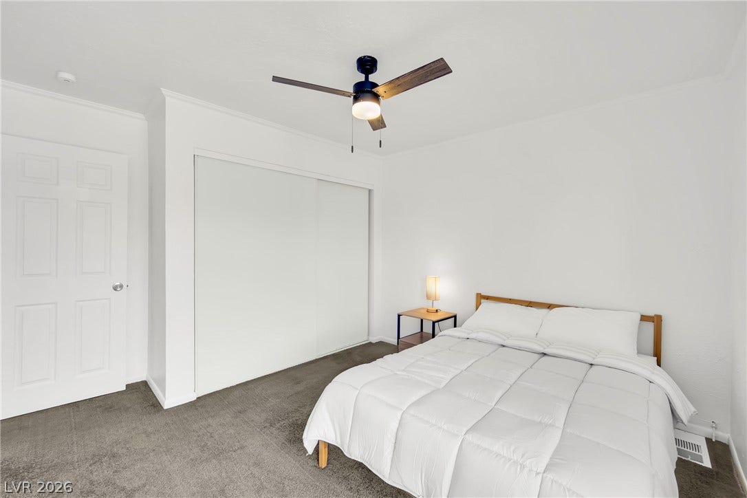 Plush carpeting and integrated sliding closet doors define this comfortable bedroom space.