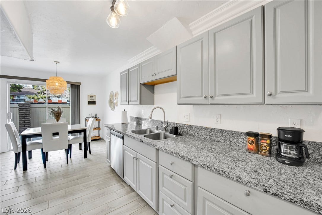 Polished stone countertops and sleek cabinetry elevate this inviting kitchen and dining area.