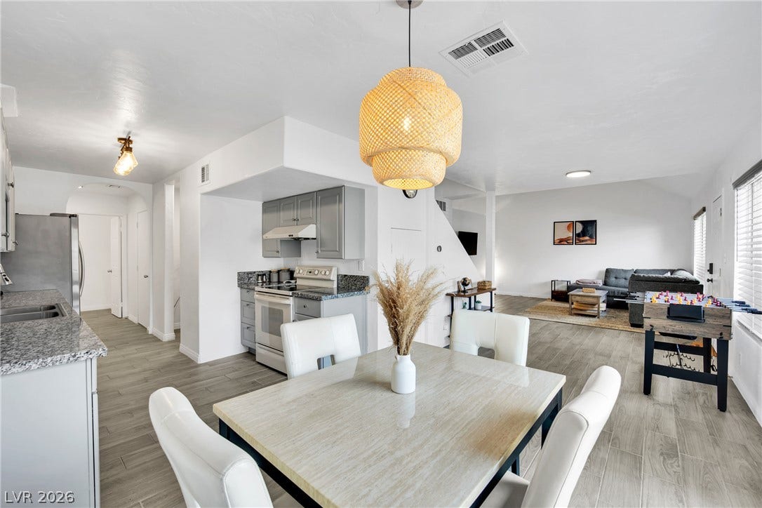 An open dining area flows seamlessly into the kitchen and living spaces under smooth ceilings.