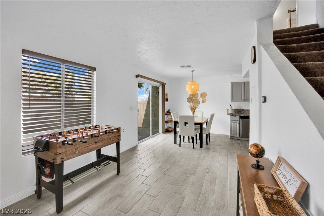 Clean-lined plank flooring runs throughout this versatile dining and recreation area.