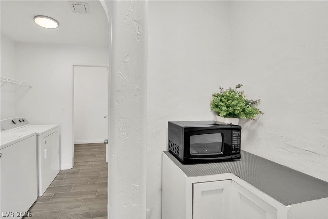 Functional utility space features durable wood-look tile flooring and clean white walls.
