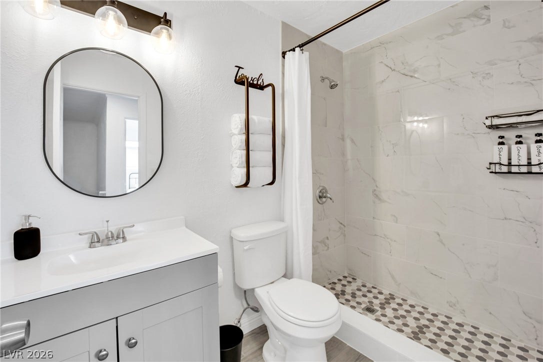 Elegant tile surrounds the walk-in shower in this modern bathroom space.