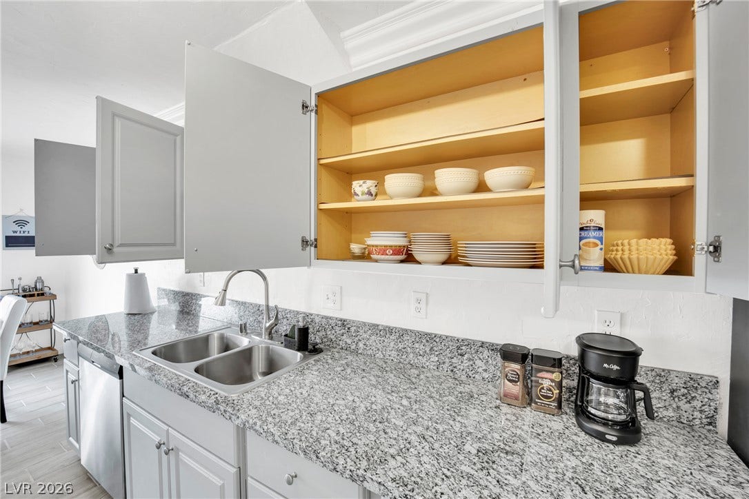 Polished granite countertops complement classic cabinetry in this bright culinary workspace.