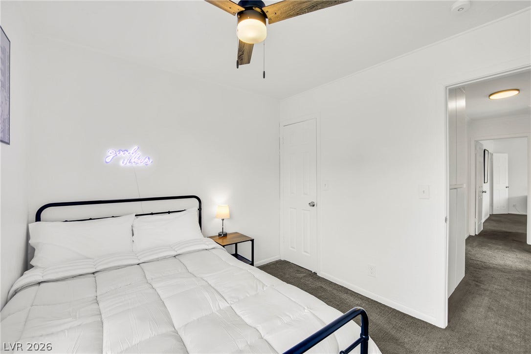 Plush carpeting and crisp white walls create a serene atmosphere in this restful bedroom.