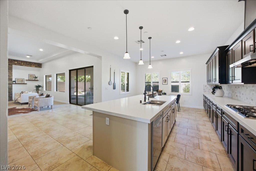 8030 Palm Cove Court, Las Vegas, NV 89129 Gleaming stone counters and warm tile floors anchor this generous, open-concept culinary space.