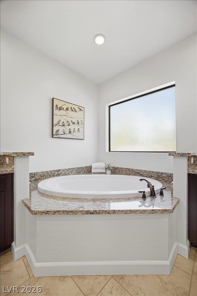 8030 Palm Cove Court, Las Vegas, NV 89129 Natural light pours over a built-in soaking tub finished with polished granite tile surrounds.