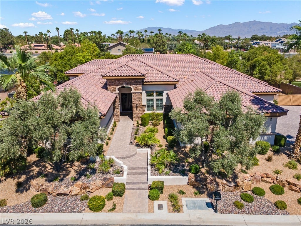 8030 Palm Cove Court, Las Vegas, NV 89129 An inviting stone-accented entryway and meticulous desert landscaping define this elegant tile-roofed residence.