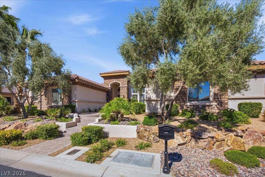8030 Palm Cove Court, Las Vegas, NV 89129 Mature trees and professional landscaping frame this elegant stone-accented residence.