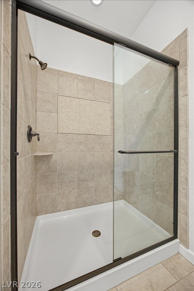 8030 Palm Cove Court, Las Vegas, NV 89129 A glass-enclosed shower is lined with neutral tiling and features a built-in shelf.