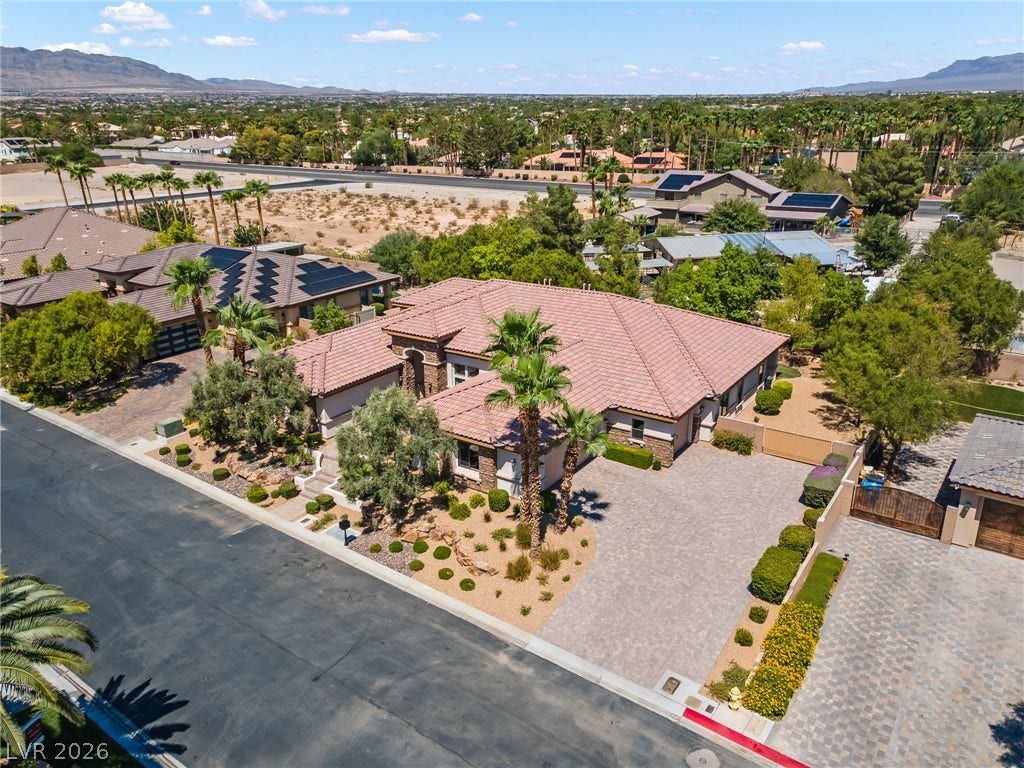 8030 Palm Cove Court, Las Vegas, NV 89129 An aerial perspective showcases the desert landscaping, tile roof, and spacious paved driveway.