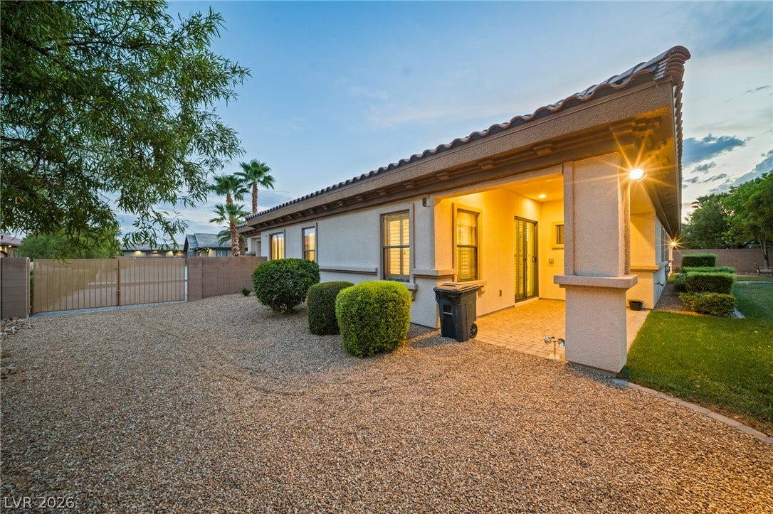 8030 Palm Cove Court, Las Vegas, NV 89129 A covered back patio with paved flooring looks out over the low-maintenance desert landscaping.