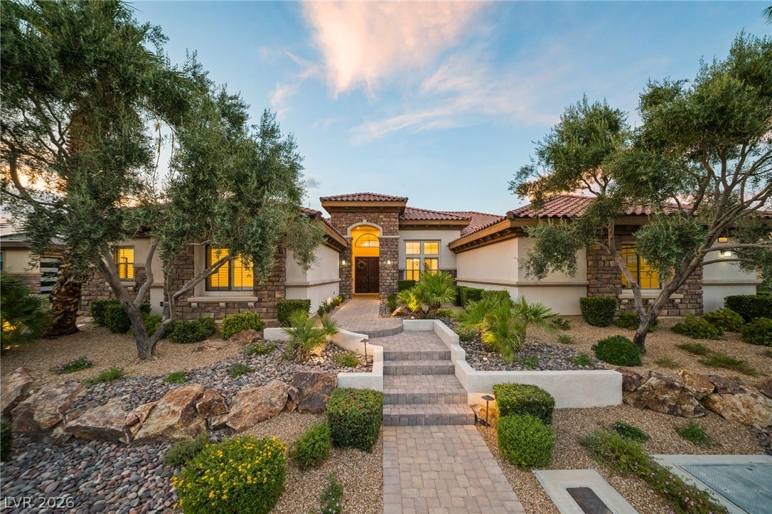 8030 Palm Cove Court, Las Vegas, NV 89129 A stone-accented exterior leads to the main entry bordered by landscaped desert stone beds.