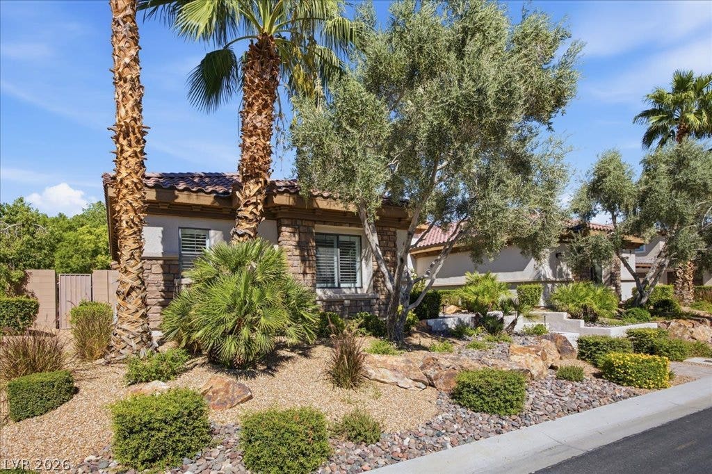 8030 Palm Cove Court, Las Vegas, NV 89129 Mature palms and desert landscaping create an inviting approach to this stone-accented residence.
