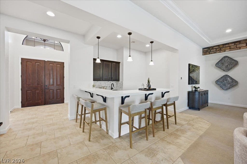 8030 Palm Cove Court, Las Vegas, NV 89129 A spacious entry foyer leads past a stylish wet bar with custom stone tile flooring.