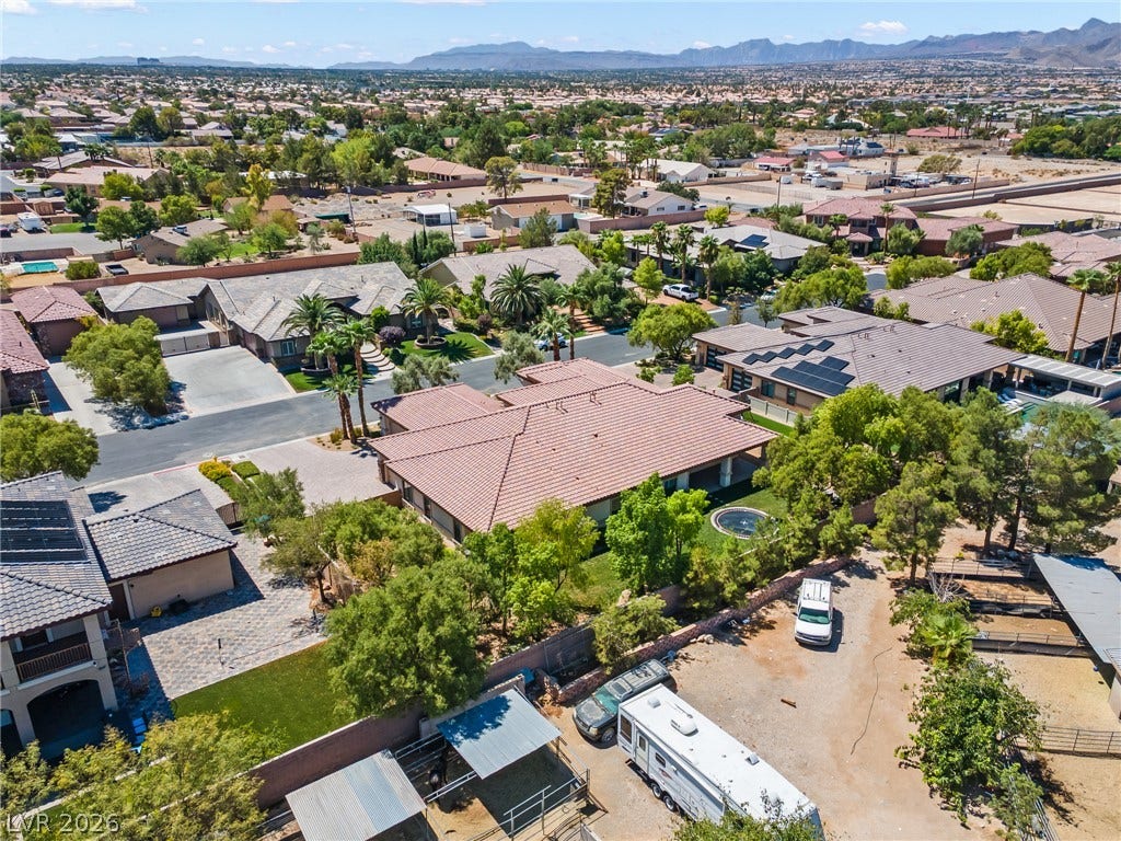 8030 Palm Cove Court, Las Vegas, NV 89129 An aerial view showcases the tile roof construction set against a mountain backdrop.