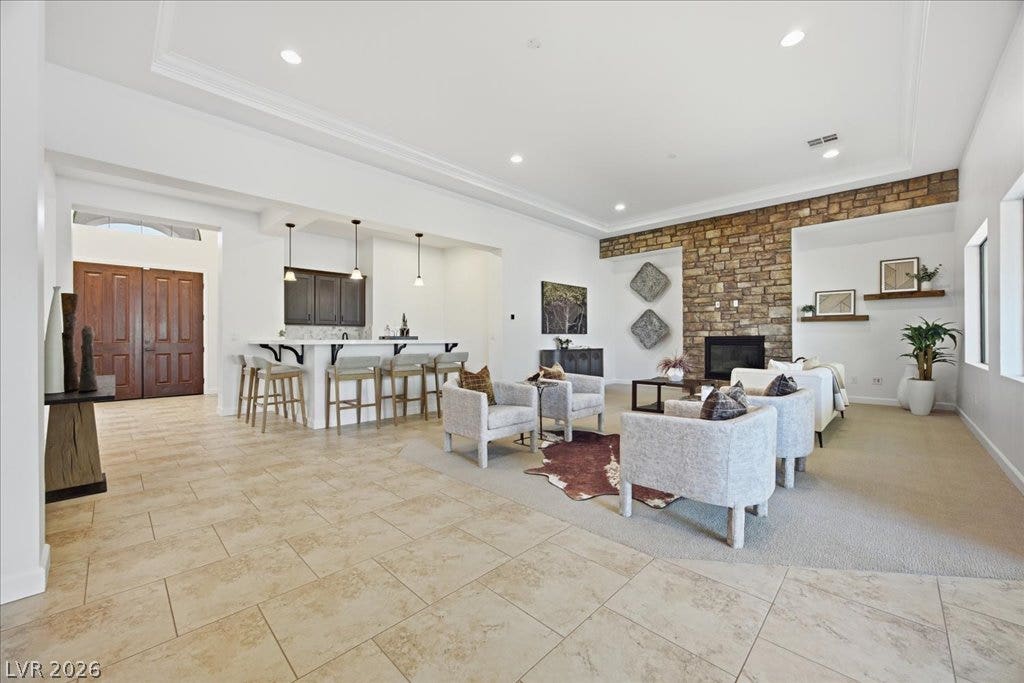 8030 Palm Cove Court, Las Vegas, NV 89129 A stone fireplace anchors the grand living space with tile flooring and recessed lighting.