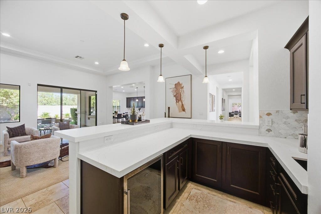8030 Palm Cove Court, Las Vegas, NV 89129 Rich dark wood cabinetry contrasts beautifully with sleek light countertops in this integrated home bar.