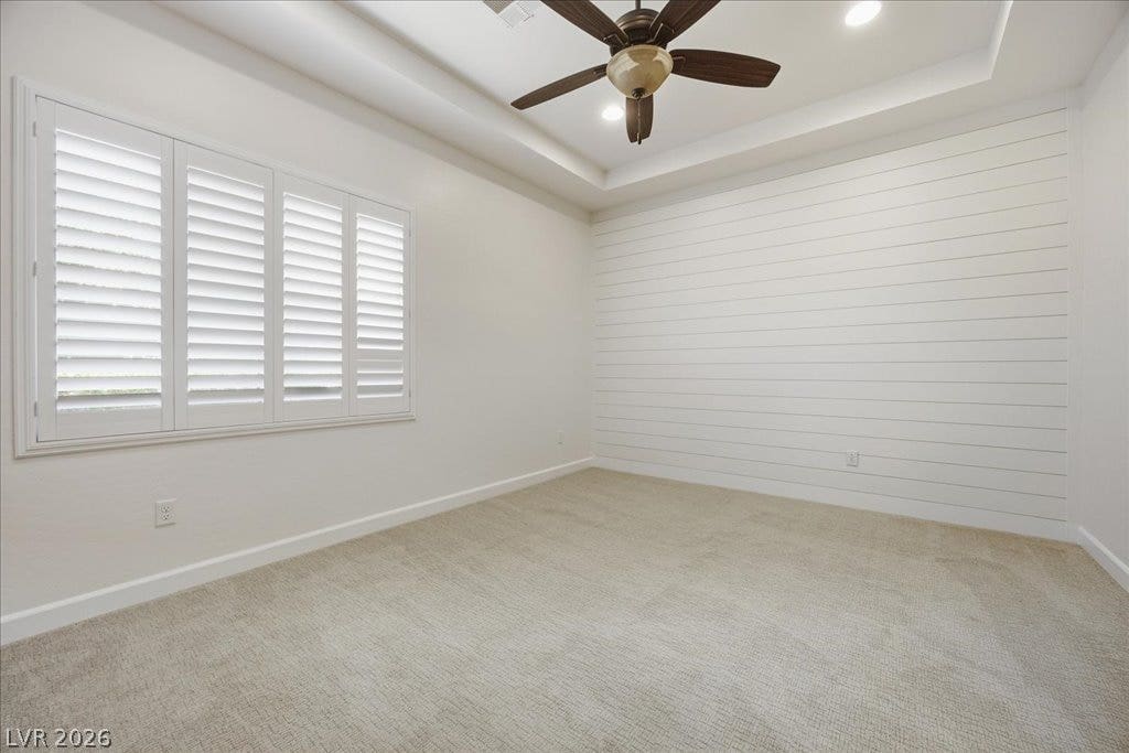 8030 Palm Cove Court, Las Vegas, NV 89129 Bedroom 2: A tray ceiling and shiplap paneling elevate this bright carpeted bedroom.